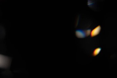 Mavi ışık prizması gökkuşağı parlamaları siyah arka plan, ışık geçişi kristalleri, prizmatik güneş yakalayıcı ışınları üzerinde etkiye sahiptir. Soyut bulanık renkli lensler koyu renk üzerinde parlıyor.