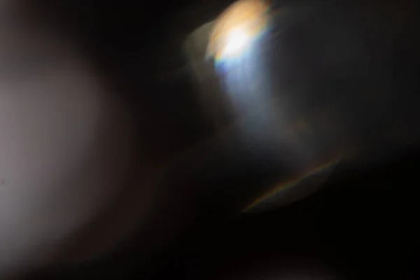 Resplandor de luz azul prisma arco iris bengalas efecto de superposición sobre fondo negro, la luz que cruza cristales, prismático sol catcher reflexiones rayos. Resumen borrosa lente de colores llamarada bokeh en la oscuridad — Foto de Stock