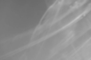 Beyaz duvar üzerindeki nedensel ışık kırılması fotoğraf modellemesini gizliyor. Bulanık güneş ışınları cam prizmayı gölgeyle kırıyor. Su yüzeyindeki soyut ışık kırılma silueti