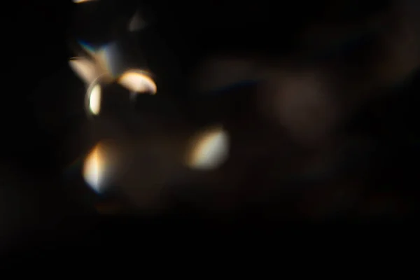 Resplandor de luz azul prisma arco iris bengalas efecto de superposición sobre fondo negro, la luz que cruza cristales, prismático sol catcher reflexiones rayos. Resumen borrosa lente de colores llamarada bokeh en la oscuridad — Foto de Stock