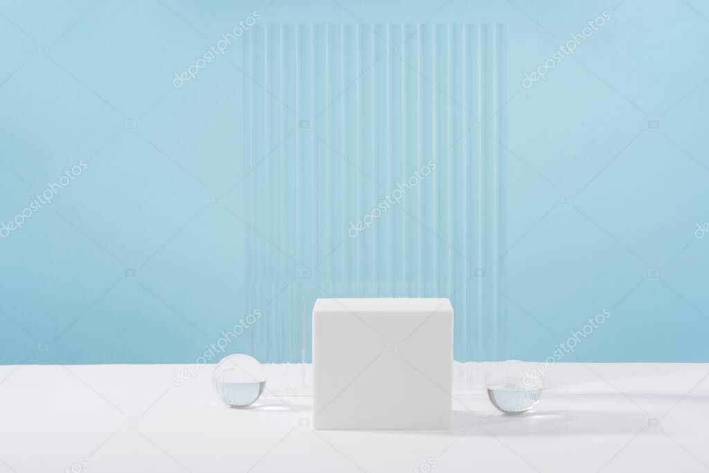 Acrylic plate, podium, background for cosmetic product packaging on blue backdrop with stylish props. Showcase for jewellery presentation, display for advertising, cosmetics branding scene mockup