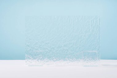 Akrilik tırtıklı plaka, mavi arka planda kozmetik ürün ambalajı için arka plan. Mücevher sunumu için vitrin, parfüm reklamı için vitrin, kozmetik ürünleri en az markalaşma sahnesi.