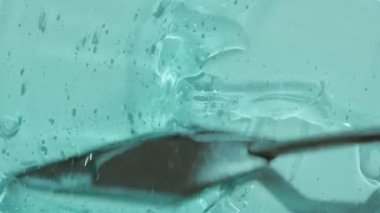Kabarcık görüntülü şeffaf hiyalüronik asit jel dokusu. Kozmetik cilt turkuaz losyon tonik peptit ve kolajenle güzellik ürünü. Mavi temizleyici soyut arkaplan videosu 4k