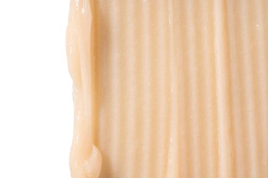 Beyaz arka planda saç kremi lekesi. Sarı kozmetik losyon nemlendirici numunesi yakın çekim. Vücut bakım kremi, retinol serumu, şampuan dalgalı doku. Cilt maskesi, kremsi temizleyici ürün