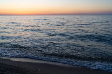 Gün batımı gökyüzü suya yansıyor, hava manzarası. Seyahat yerleri, tatil konsepti. Meditasyon okyanusu ve panoramik plaj manzarası. Turuncu ve altın tavan penceresi sakinliği yaz havasını rahatlatıyor..
