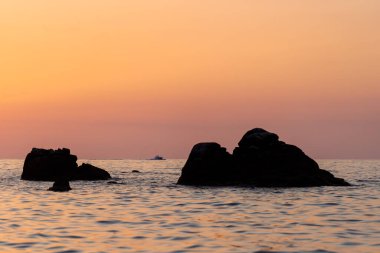 Beautiful view of orange sunset seascape with rocks in Italy. Tropical colorful sunrise landscape