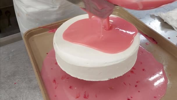 将白色巧克力釉料倒在草莓蛋糕上并撒布 — 图库视频影像