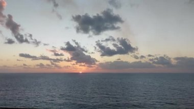 İstiridye okyanusu ve bulutlu akşam güneşi.