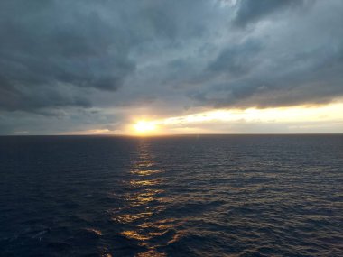 Altın gün batımı ve bulutlu gökyüzü, bir yolcu gemisinden manzara