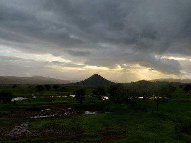 beautiful river near mountain under cloudy sky and a rice field