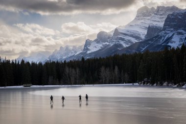 Bir grup insan Banff Canada yakınlarındaki Kanada kayalıklarında buz pateni yapıyor..