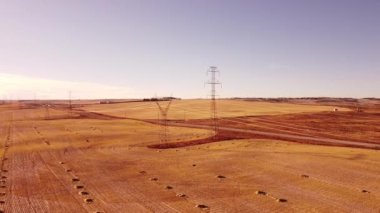 Yayın kuleleri boyunca yüksek hava dönüşleri ve Alberta Kanada 'da hasat edilen buğday tarlası.
