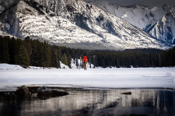 Jääkiekkoilija Pitää Taukoa Pelatessaan Jäätyneellä Vuoristojärvellä Banff Albertassa Kanadassa — kuvapankkivalokuva