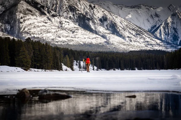 一名冰球运动员在加拿大班夫阿尔伯塔省一个冰冻的高山湖上玩耍时休息一下 — 图库照片