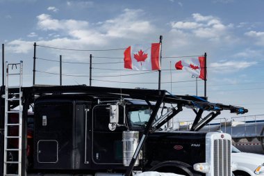 Calgary Alberta Canada, 4 Şubat 2022: Kanada Bayrağı dalgalanan yerel bir kamyon durağında park etmiş bir Özgürlük Konvoyu yarı kamyon destekçisi.