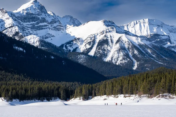 在加拿大落基山脉整洁的班夫加拿大 人们踩着雪鞋穿过被雪覆盖的草地 — 图库照片