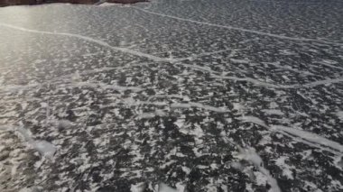 Büyük buz çatlakları ve Alberta Kanada 'da park halindeki araçlarla donmuş bir çayır gölünün havadan yansıması..