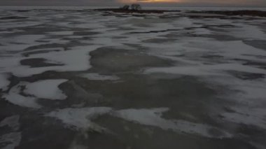 Gün batımında, donmuş göl ve Tundra ile çevrili ıssız bir adadaki yavaş hava eğimlerini gösteriyor..