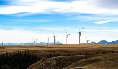 Rüzgâr türbinleri, Pincher Creek Alberta Kanada yakınlarında Kanadalı Rocky Dağları 'nın arka planında elektrik üretiyor..