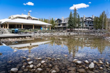 Kananaskis Alberta Kanada, 16 Mayıs 2022: Alberta Kanada 'da lüks Marriott Kananaskis Dağ Lodge' da gölet yapan bir adama su yansıması.