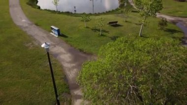 Airdrie Alberta Canada, Haziran 07 2022: Sabah ışığı altında alabalık ve su çeşmesiyle dolu fırtına kanalizasyon havuzu olan bir şehir parkının havadan eğilimi ortaya çıktı.