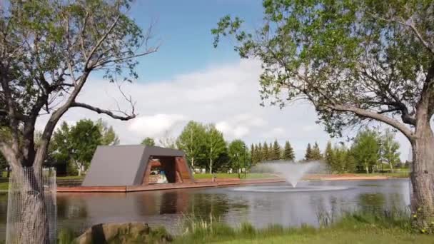 Airdrie Albertaカナダ 2022年6月7日 鼻クリーク公園の水路に2本の木を通して空中追跡運動 — ストック動画