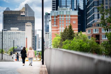 Calgary Alberta Kanada, 2 Temmuz 2022: Yeni Prenses Adası Park Jaipur yaya köprüsünden şehir merkezine doğru yürüyen insanlar.