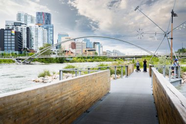 Calgary Alberta Canada, 2 Temmuz 2022: St. Patricks Adası 'nda halk sanatları sergisi ve şehir merkezi silueti ile yürüyen insanlar.