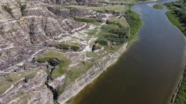 Aerial flight over the Red Deer River and the Canadian Badlands during summer near Drumheller Alberta.
