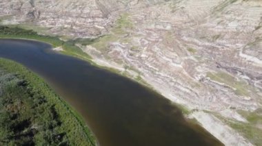Aerial view over the Red Deer River and hoodoos of the Canadian Badlands during summer near Drumheller Alberta.