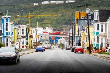 St. John 's Newfoundland Kanada, 11 Eylül 2022: Renkli Jöle Fasulye Evleri arka arkaya eski bir caddeden limana doğru teknelerle bakıyor.
