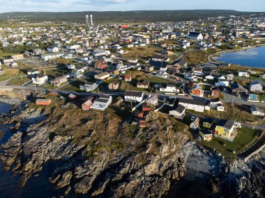 Bonavista Newfoundland Kanada, 19 Eylül 2022: Uzak su kuleleri olan kayalık kıyılarda renkli sahil evleri olan Aerial East Coast kasabası