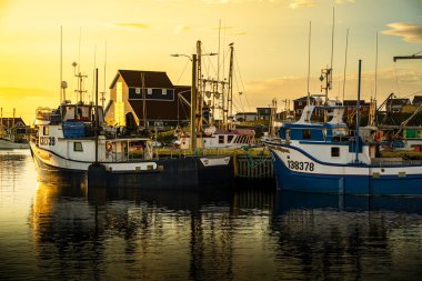 Bonavista Newfoundland Kanada, 19 Eylül 2022: Denizcilerin doğu kıyısındaki bir limanda demirlemiş balıkçı teknelerinin günbatımı sahnesi.