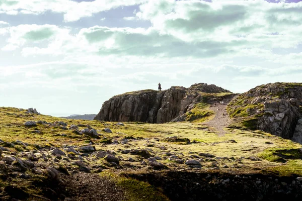 Newfoundland Kanada 'daki Bonavista Yarımadası' ndaki Atlantik Okyanusu 'na bakan kayalık bir deniz kıyısında fotoğraf çeken bir turist.