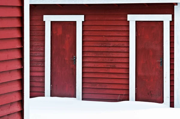İki kırmızı kapının önünde kar