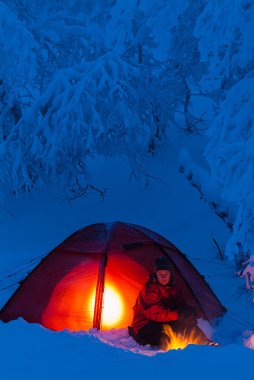 Karla kaplı ormanda kış kampı.
