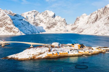 Karla kaplı dağların önündeki köprüden adaya, Norveç.
