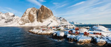 Norveç 'in karla kaplı dağının önündeki binalar.