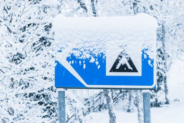 Snow covered camping sign at road clipart