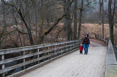 Anne ve çocuk köprüde yürüyor.