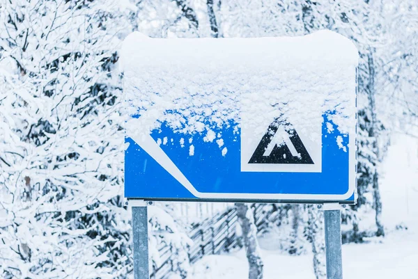 Snow covered camping sign at road