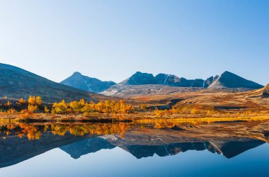 Reflection of Rondane mountains in a small lake. Rondane National park, Norway, Europe clipart