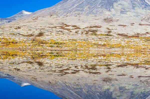 Mountain reflected in still lake, Rondane National park, Norway.