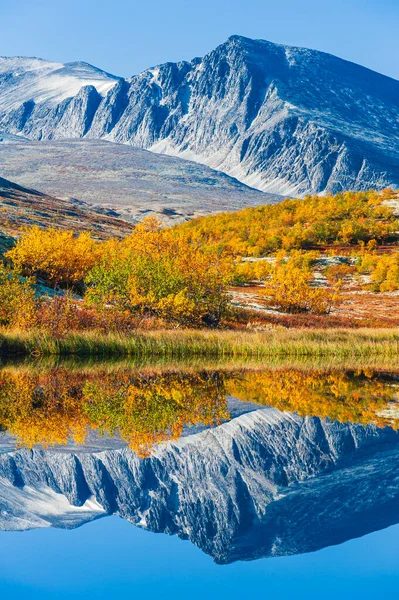 Mountain reflected in still lake, Rondane National park, Norway.