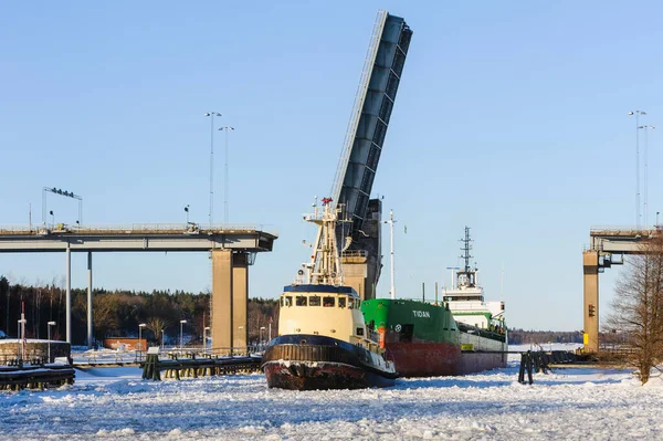 Tug boat and ship passing bridge