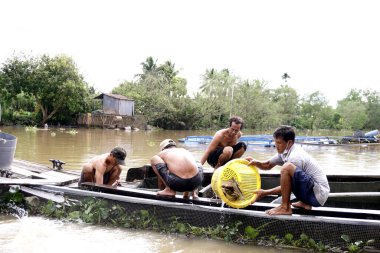 Erkekler sallarda çiftlik balığı bırakır.