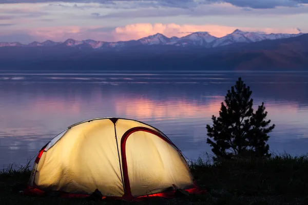 Tält över vackra solnedgången på sjön Stockfoto