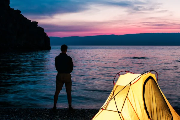 Silhouette de l'homme près de la tente au bord du lac — Photo