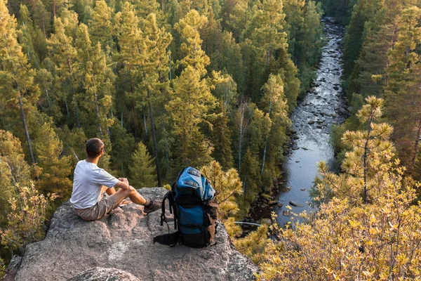 Mochilero se sienta en la roca y mira una hermosa vista — Foto de Stock