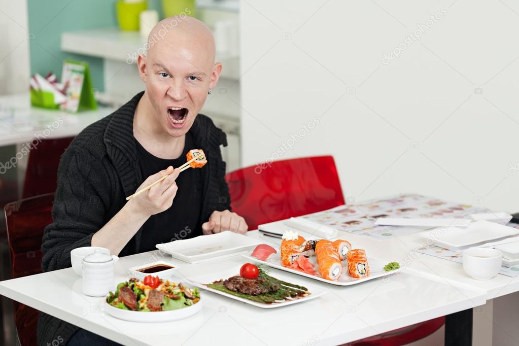 Man eats sushi. 